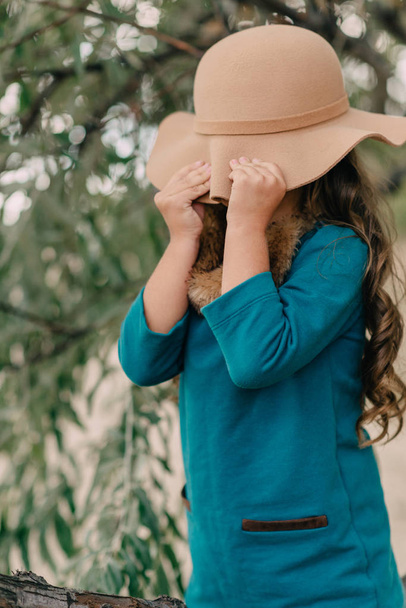 little girl in a hat with long hair - 写真・画像