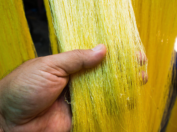 Hand plukken van een gele ruwe zijde - Foto, afbeelding