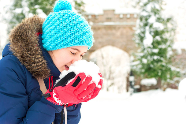 Veselá dospívající dívka drží haldy měkkého sněhu - Fotografie, Obrázek