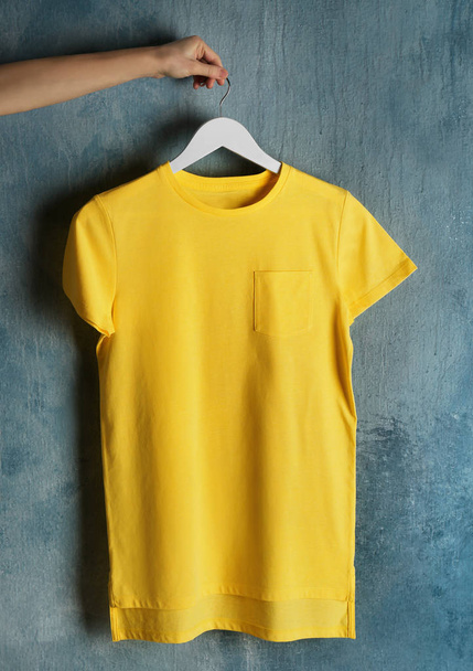 yellow t-shirt against grunge wall - Fotoğraf, Görsel