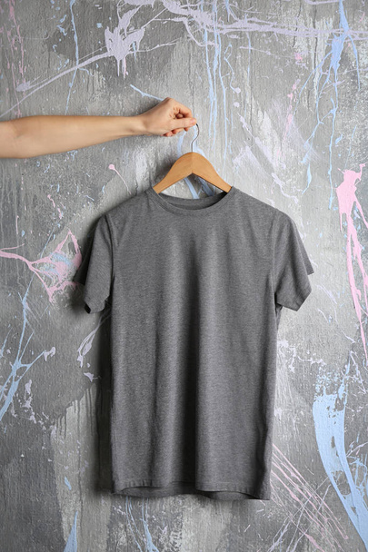 gray t-shirt against grunge wall - Foto, Bild