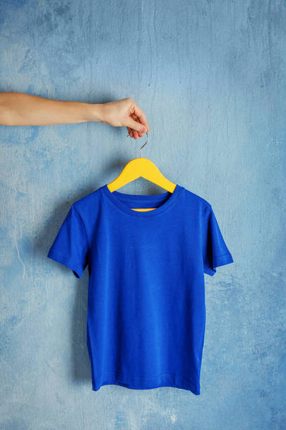blue t-shirt against grunge wall - Φωτογραφία, εικόνα