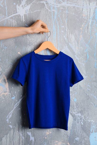 blue t-shirt against grunge wall - Foto, imagen