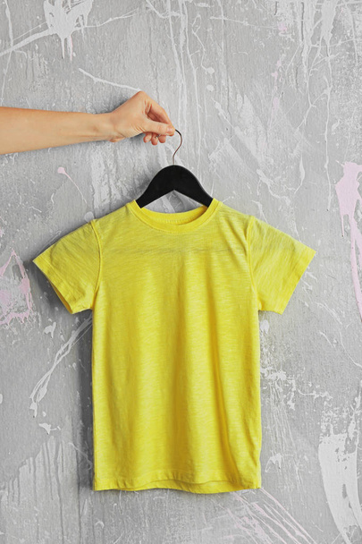 yellow t-shirt against grunge wall - Фото, зображення