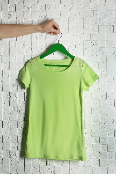green t-shirt against brickwall - Foto, Bild