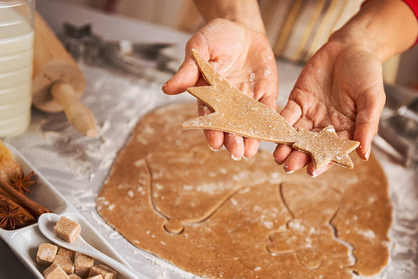 Closeup on young housewife showing carved from dough christmas c - Foto, Imagem