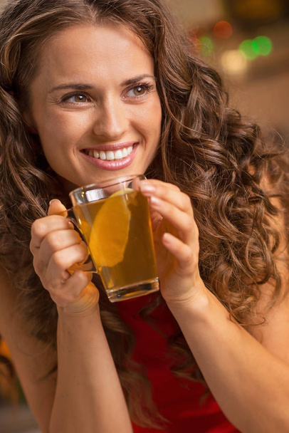 Happy young woman drinking ginger tea with lemon - Fotó, kép