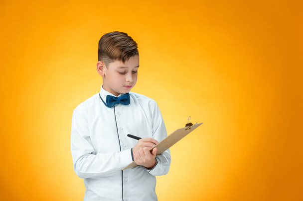 The boy with pen and tablet for notes - 写真・画像