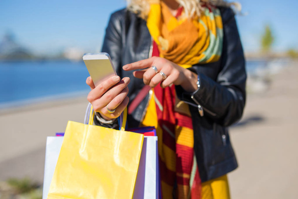 Žena s nákupní tašky chatování na smartphone - Fotografie, Obrázek