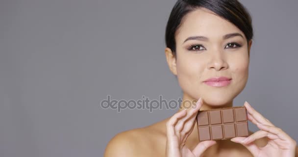 Sensual joven mujer mordisqueando en una barra de chocolate
 - Imágenes, Vídeo