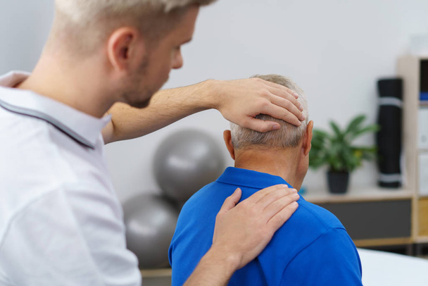 Физиотерапевт массирует шею пожилого пациента
 - Фото, изображение