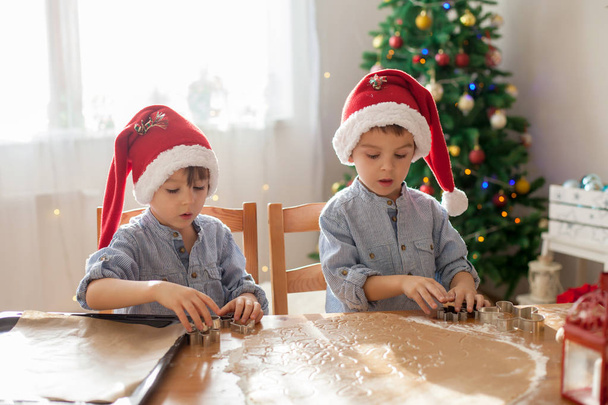 Two cute boys with santa hat, preparing cookies at home, Christm - 写真・画像