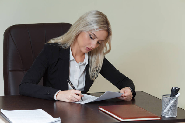 zakenvrouw ondertekening van een contract of een document in een bureau op kantoor - Foto, afbeelding