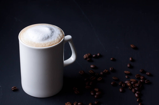 a mug of latte coffee on a black background - Valokuva, kuva