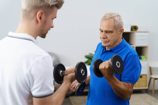 Senior man working out with trainer - Фото, зображення