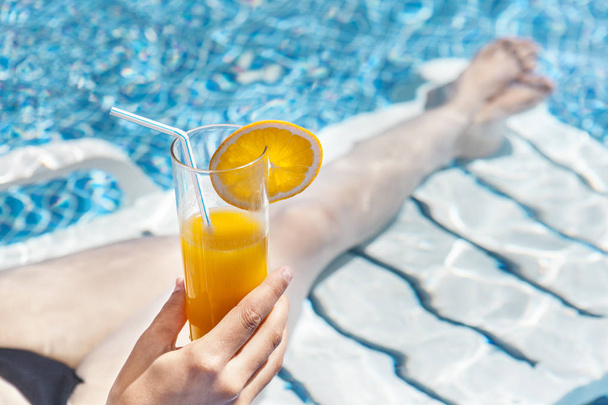 Woman enjoying a orange juice at the swimming pool - Fotografie, Obrázek