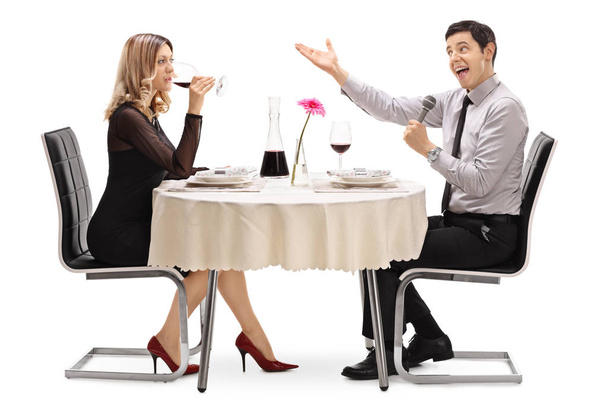 Man singing to a woman at a restaurant table - Fotografie, Obrázek