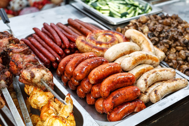 Assorted German sausages grilled in a steel container - Foto, Bild