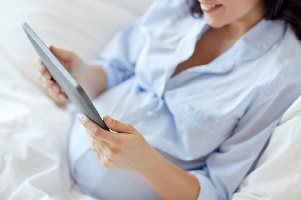 タブレット pc を自宅で妊娠中の女性のクローズ アップ - 写真・画像