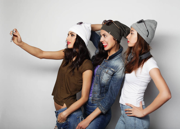 teenage girls friends in hipster outfit   make selfie on a phone - Zdjęcie, obraz