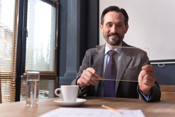 Cheerful successful businessman holding a the tablet - Photo, Image