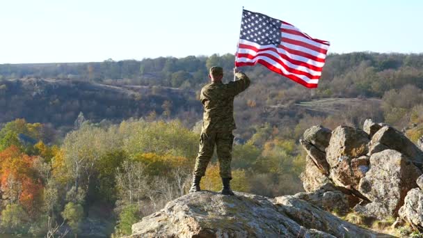 Soldat mit amerikanischer Flagge steht auf dem Gipfel des Berges. Zeitlupe  - Filmmaterial, Video