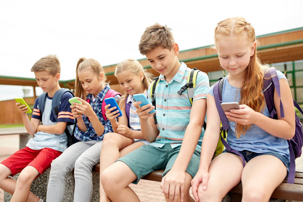 elementary school students with smartphones - Фото, изображение