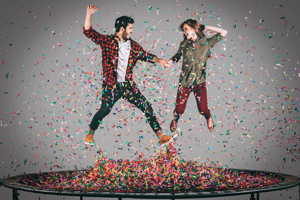 cheerful couple jumping on trampoline  - 写真・画像
