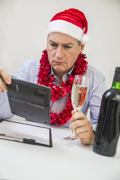 Business Man Celebrate Merry Christmas And Happy New Year Wear Santa Hat. Serious minded man thinking about way to solve his problems on new year eve - Фото, изображение