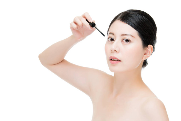 young beautiful asian woman applying mascara on eyelashes - Foto, Imagem
