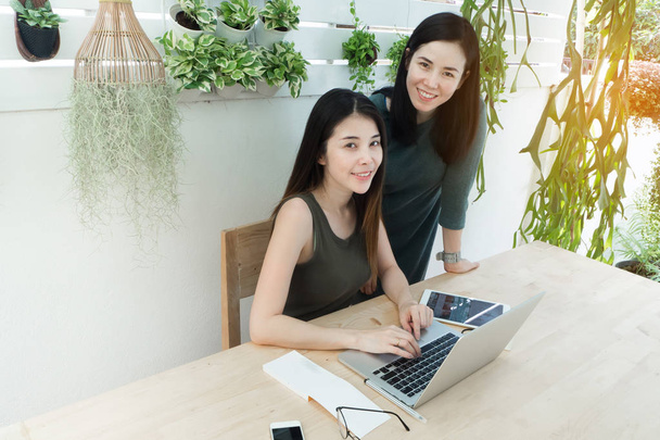 Visage souriant femmes utilisant un ordinateur portable dans le lieu de travail à la maison, Lieux de travail
 - Photo, image