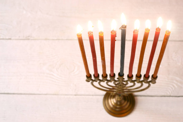 Hanukkah menorah with burning candles on the white wooden table horizontal - Фото, изображение