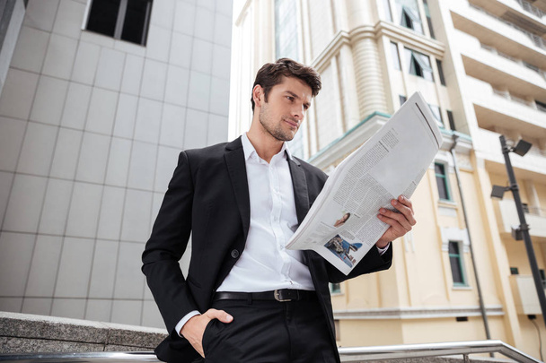 Businessman reading newspaper in the city - Zdjęcie, obraz