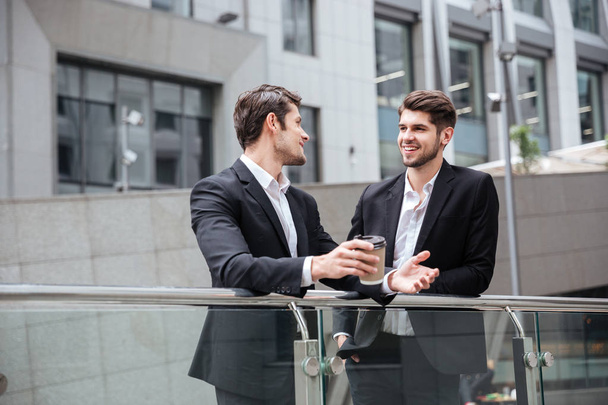 Dos hombres de negocios hablando y tomando café en la ciudad
 - Foto, imagen