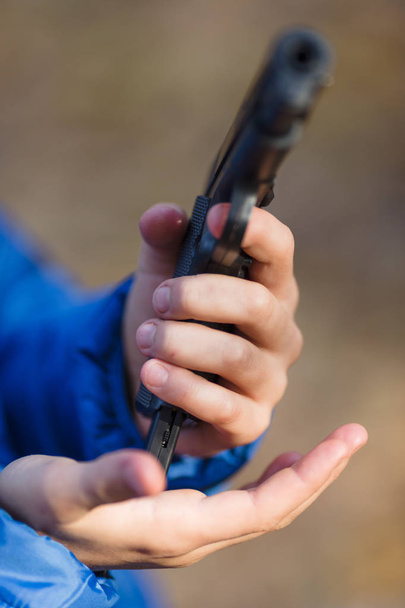 chłopiec gry z pistoletem-zabawką na ulicy jesienią - Zdjęcie, obraz