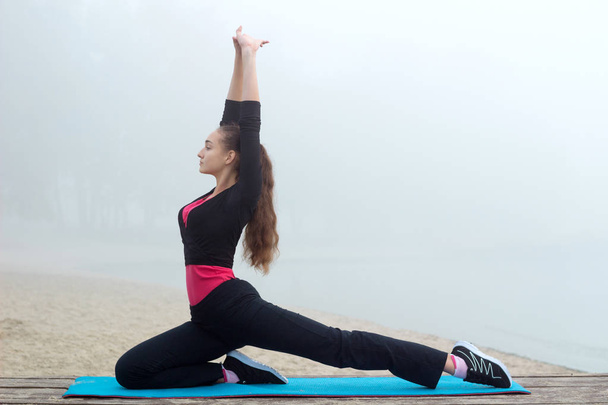 Молода спортивна жінка розтягується під час тренувань на відкритому повітрі
 - Фото, зображення