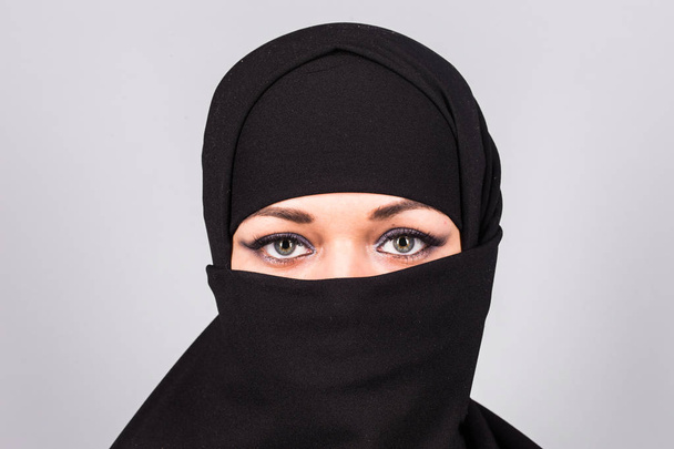 Young woman wearing niqab on background - Foto, Imagen
