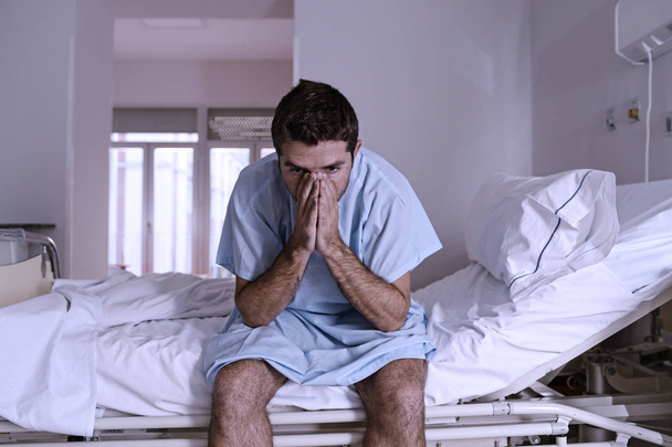 zdesperowany mężczyzna siedzi w szpitalu łóżku sam smutny i zdewastowany s - Zdjęcie, obraz