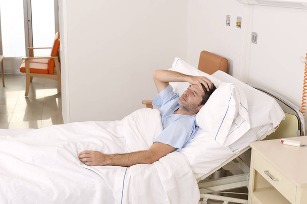 hever a kórházi ágyon pihent, fáradt, szomorú és depressziós beteg fiatalember aggódik - Fotó, kép