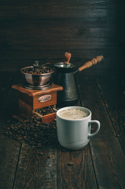 Coffee cup, mill and jezve on dark rustic table - Photo, Image
