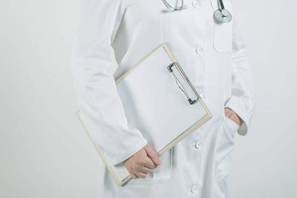 Женщина-врач позирует с блокнотом и чистой бумагой
 - Фото, изображение