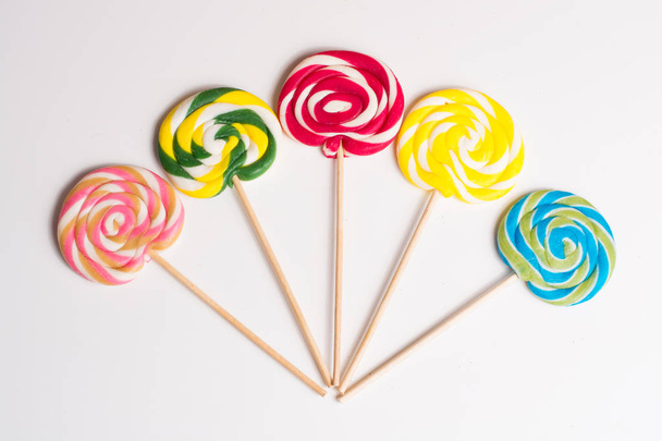 Multicolored sweet candy canes on wooden sticks isolated - Photo, Image