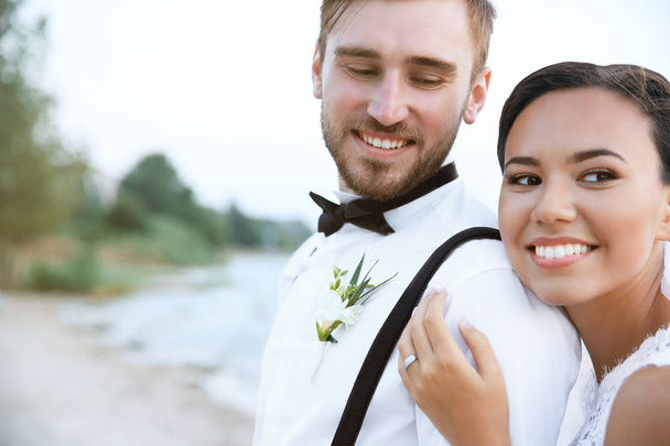 Groom and bride on river bank - Foto, afbeelding
