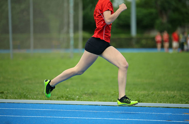 κορίτσι τρέχει γρηγορότερα μέσα στην πίστα κατά τη διάρκεια ενός διαγωνισμού σπορ - Φωτογραφία, εικόνα