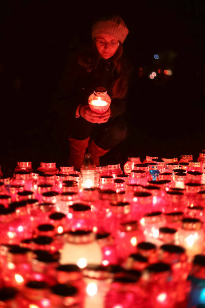 Γυναίκα μπροστά από το κάψιμο των κεριών - Φωτογραφία, εικόνα