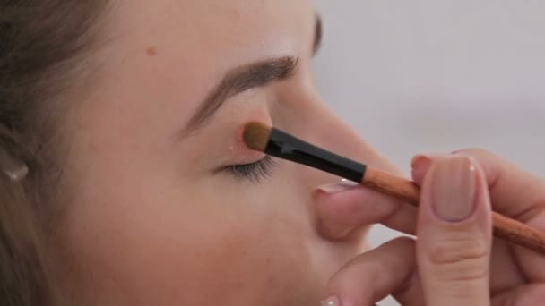 Close-up shot. Professionele make-up artiest toepassing van oogschaduw - Video