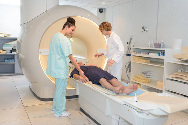 nurse and radiologist preparing patient for ct scan - Foto, Imagem