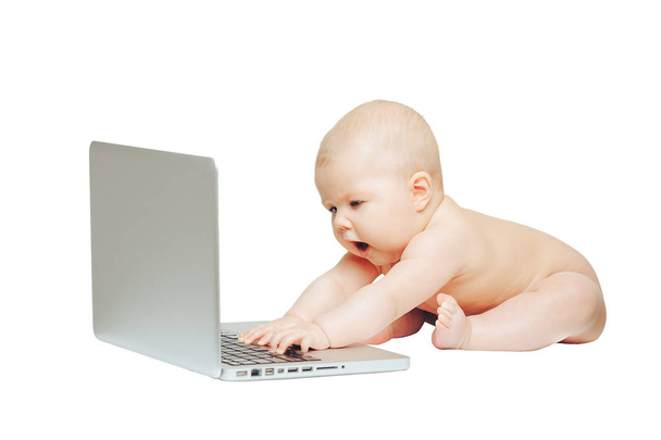 Child sits in front of a laptop and push buttons - Photo, Image