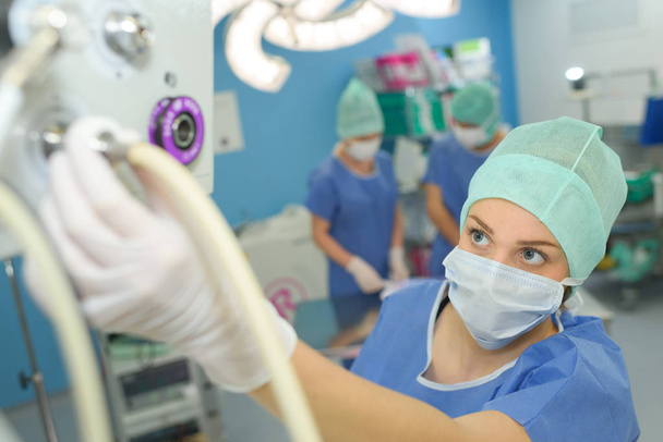 female surgeon setting up medical machine - Фото, изображение