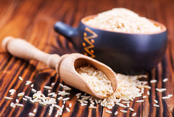 riz cru dans une cuillère et un bol en bois
 - Photo, image
